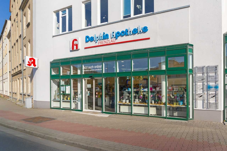 Eingangsbereich im Sonnenlicht Aluminium grün und Glasfassade mit Logo darüber in Prenzlau