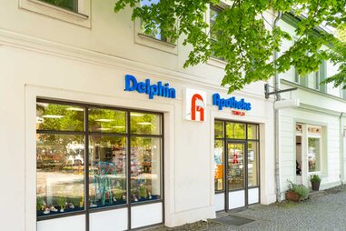 Delphin Apotheke im Frühling von aussen mit Glasfassade